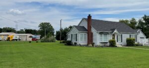 Two One Waste Solutions garbage trucks visible in the background of a residential area in Murfreesboro, TN, providing junk removal.