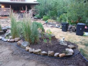 A newly landscaped garden bed with rocks and plants by Shane's Handyman Service in Edmond, OK.