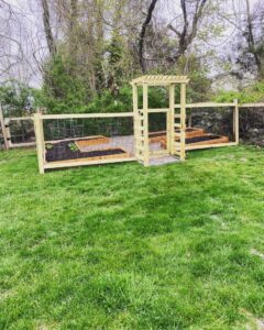 A garden area featuring newly built raised beds and a wooden arbor by Woodbine Repair & Remodeling in Jamestown, RI.