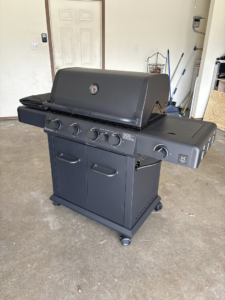 A newly assembled gas grill in a garage, showcasing assembly service by Express Handyman Pros, LLC in Fort Smith, AR