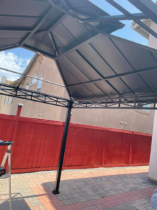 A partially assembled metal gazebo structure on a paved patio, showing outdoor construction work by Handyman SanDiego in San Diego, CA.