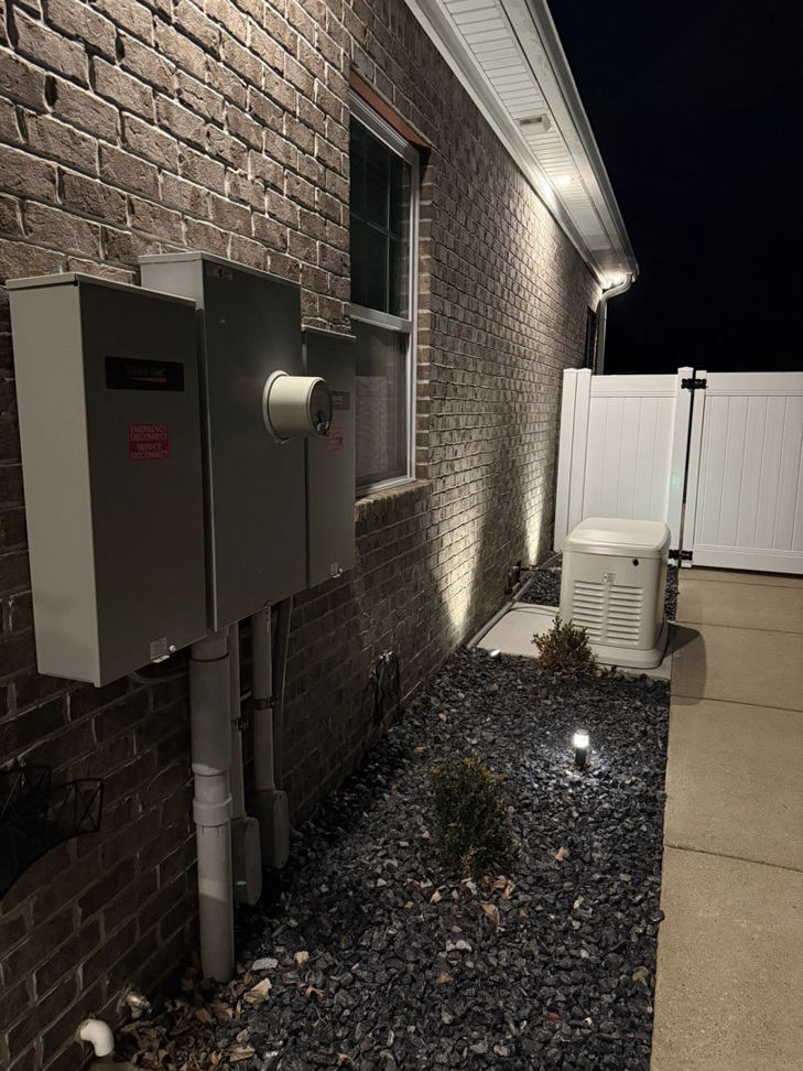 A Generac whole-house generator installed at night with exterior lighting by Morris Electrical Service in Hopkinsville, KY.