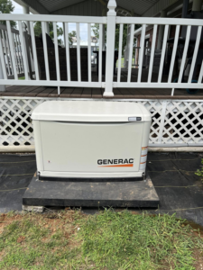 A Generac whole-house generator installed next to a residential porch by Morris Electrical Service in Hopkinsville, KY.