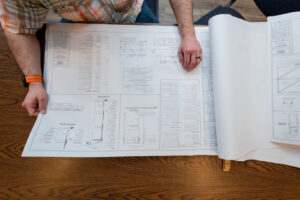 A general contractor reviewing architectural blueprints for a project by Overstreet Builders, Inc. in Naperville, IL.