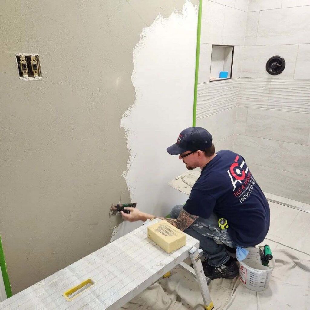 A general contractor applying a smooth finish to a wall, demonstrating expert finishing services by Ace Tile & Finishing LLC in Philadelphia, PA.