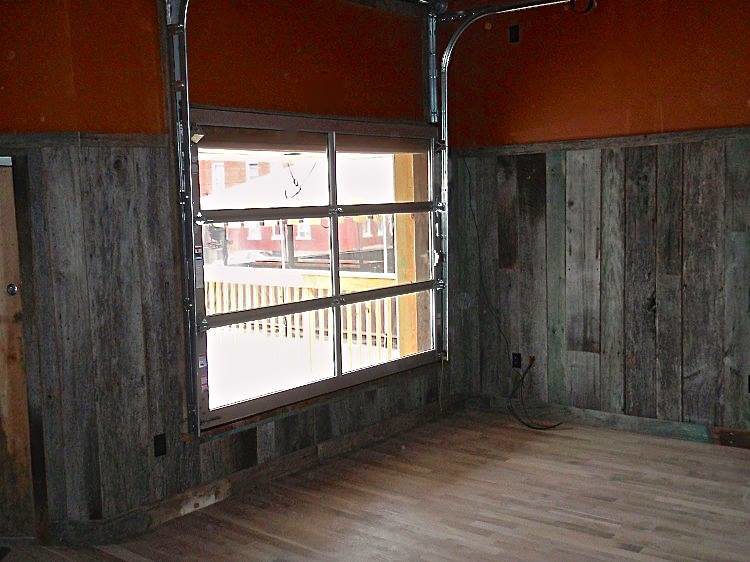 Installation of a glass garage door and wooden wall paneling by Triad Construction Company LLC in Ashland City, TN.
