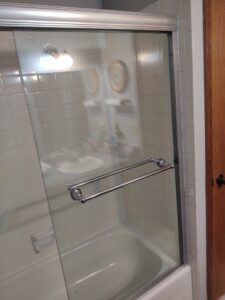 A newly installed glass shower door in a bathroom, a service provided by IFixdIt Handyman Services in Omaha, NE.