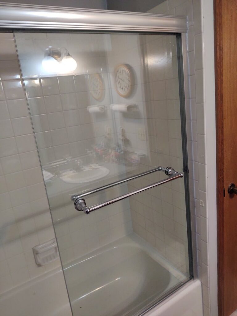 A newly installed glass shower door in a bathroom, a service provided by IFixdIt Handyman Services in Omaha, NE.