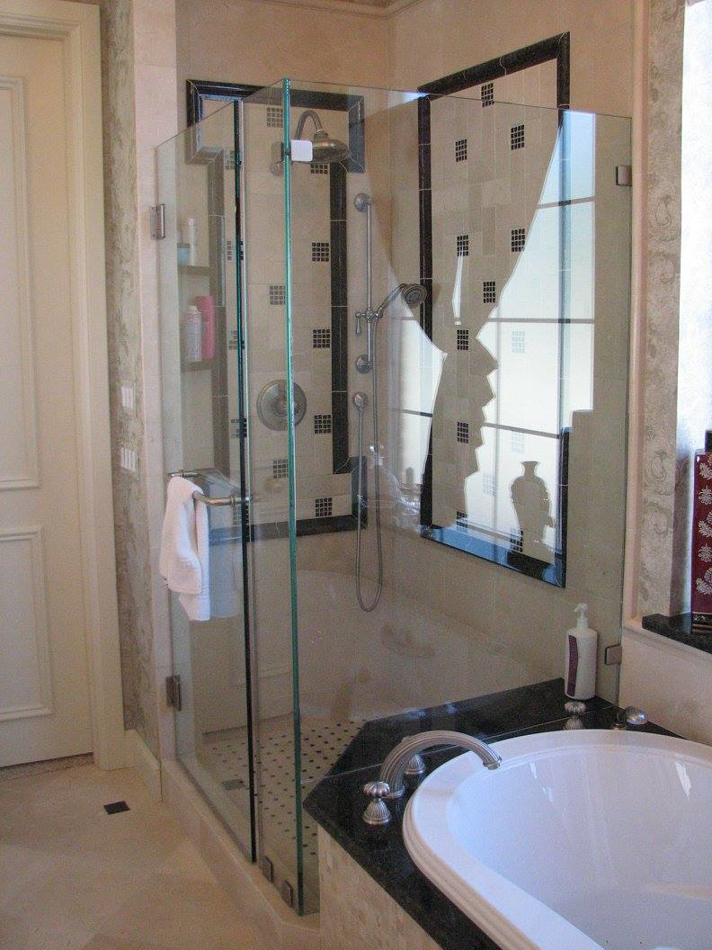 A modern glass shower enclosure installed next to a bathtub by Metro Contractors & Supply, Inc. in Norman, OK
