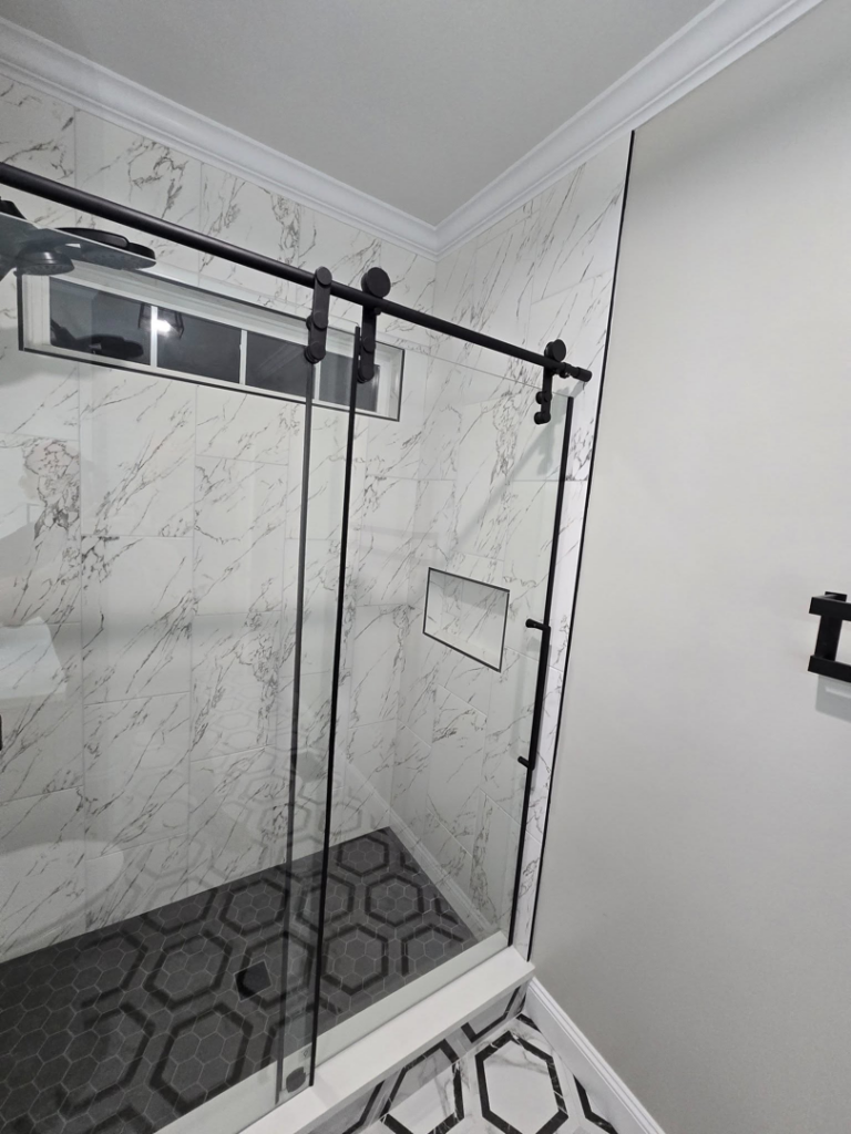 Newly installed glass shower enclosure with modern tile work by Hollis Construction in Nashville, TN.