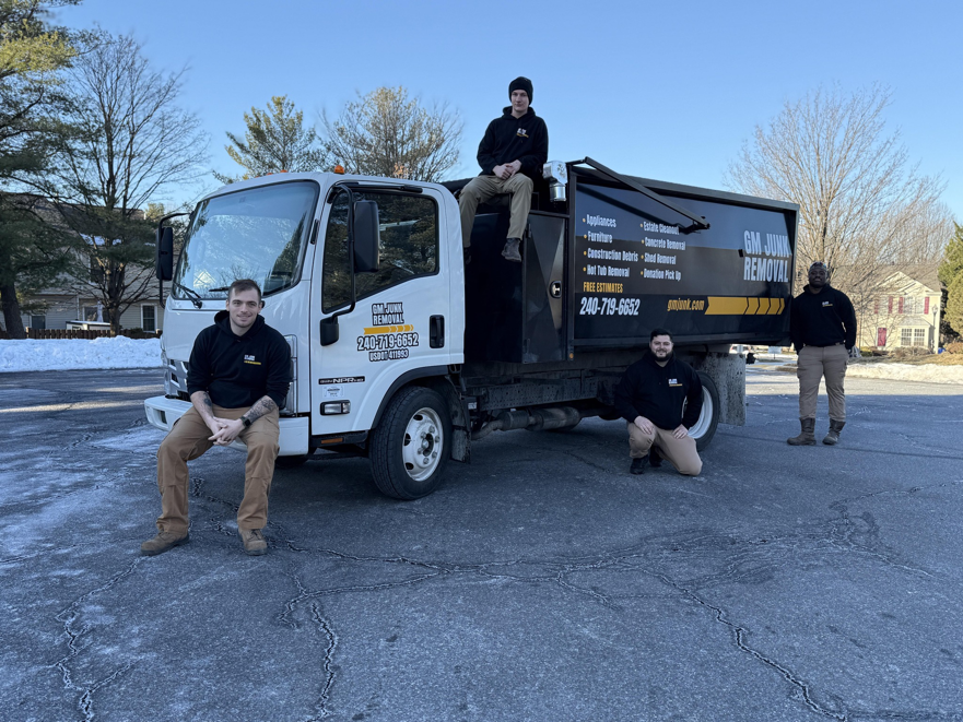 The GM Junk Removal team posing with their junk removal truck in Frederick, MD.
