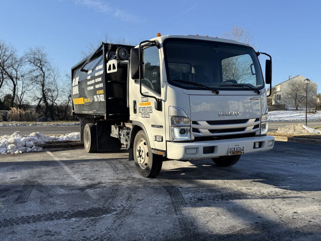 A GM Junk Removal truck parked in a snowy lot, ready for service in Frederick, MD.