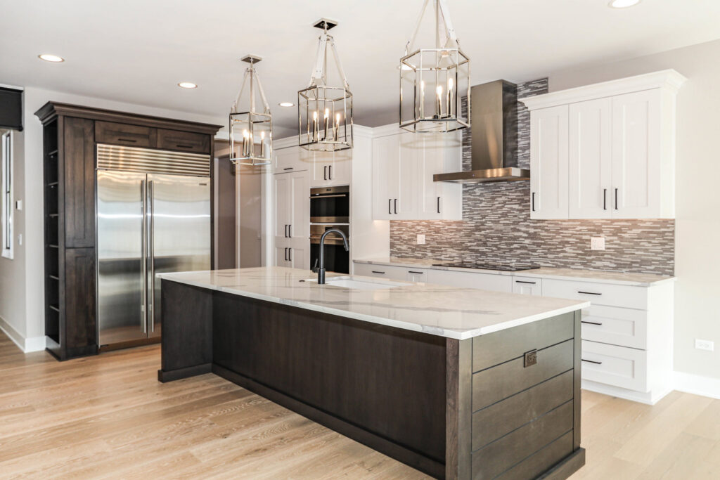 A gourmet kitchen with a dark wood island, white countertops, and stainless steel appliances by DJK Custom Homes in Naperville, IL