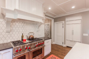 A gourmet kitchen featuring a professional range, custom range hood, and decorative backsplash, completed by Legacy Builders Group in Cincinnati, OH.