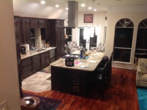 A gourmet kitchen renovation with dark wood cabinets and a granite island by All Star Construction, Inc. in Houston, TX.