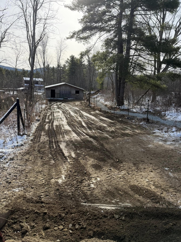 A graded muddy driveway showing site preparation work by Naz General Contracting LLC in Schenectady, NY.