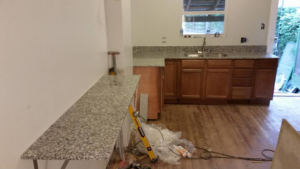 A granite countertop installation project in progress, showing a long counter section by Alfortish Marble & Granite, LLC in Baton Rouge, LA.