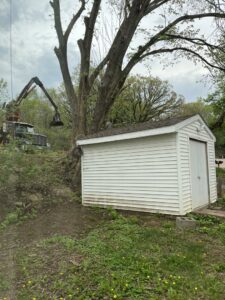 A grapple truck and pile of tree debris at a job site, showcasing the cleanup services of Jeff's Tree Service in Sioux City, IA.