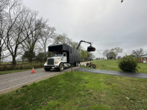 A grapple truck loads tree branches and debris from the roadside for 4M Tree Service in Knoxville, TN.