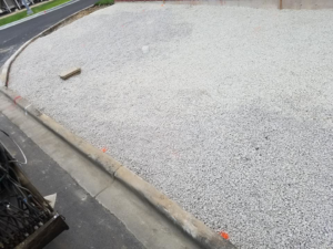A prepared gravel base and concrete curb, indicating general contractor site work by National Kurb Kut in Naperville, IL.