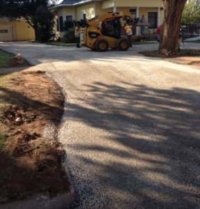 Gravel driveway construction in progress with a skid-steer loader by Driveway Experts in Denver, CO.