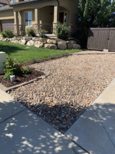 A newly installed gravel driveway and landscaping with decorative rocks and plants, completed by Jake and Jake Construction LLC in Sandy, UT.