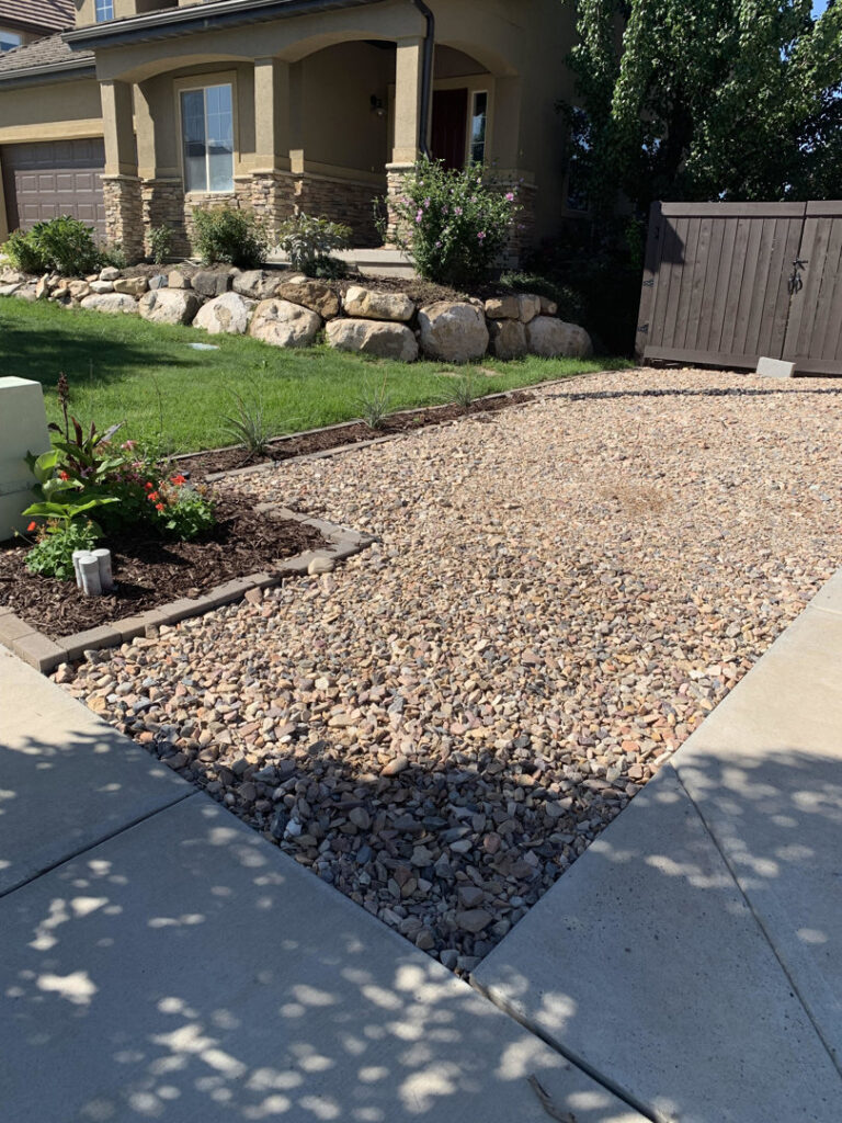 A newly installed gravel driveway and landscaping with decorative rocks and plants, completed by Jake and Jake Construction LLC in Sandy, UT.