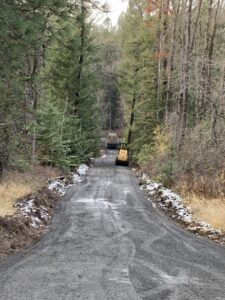A gravel road under construction or maintenance, with excavation equipment in the distance, by Aspen Excavation in Spokane, WA.