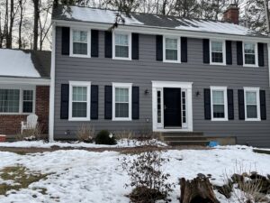 A gray house with new siding, black shutters, and a black front door, completed by Bartlett Brainard Products Co. in West Hartford, CT.