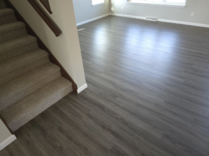 New gray wood-look laminate flooring and carpeted stairs installed by L.A. Floors in Madison, WI.
