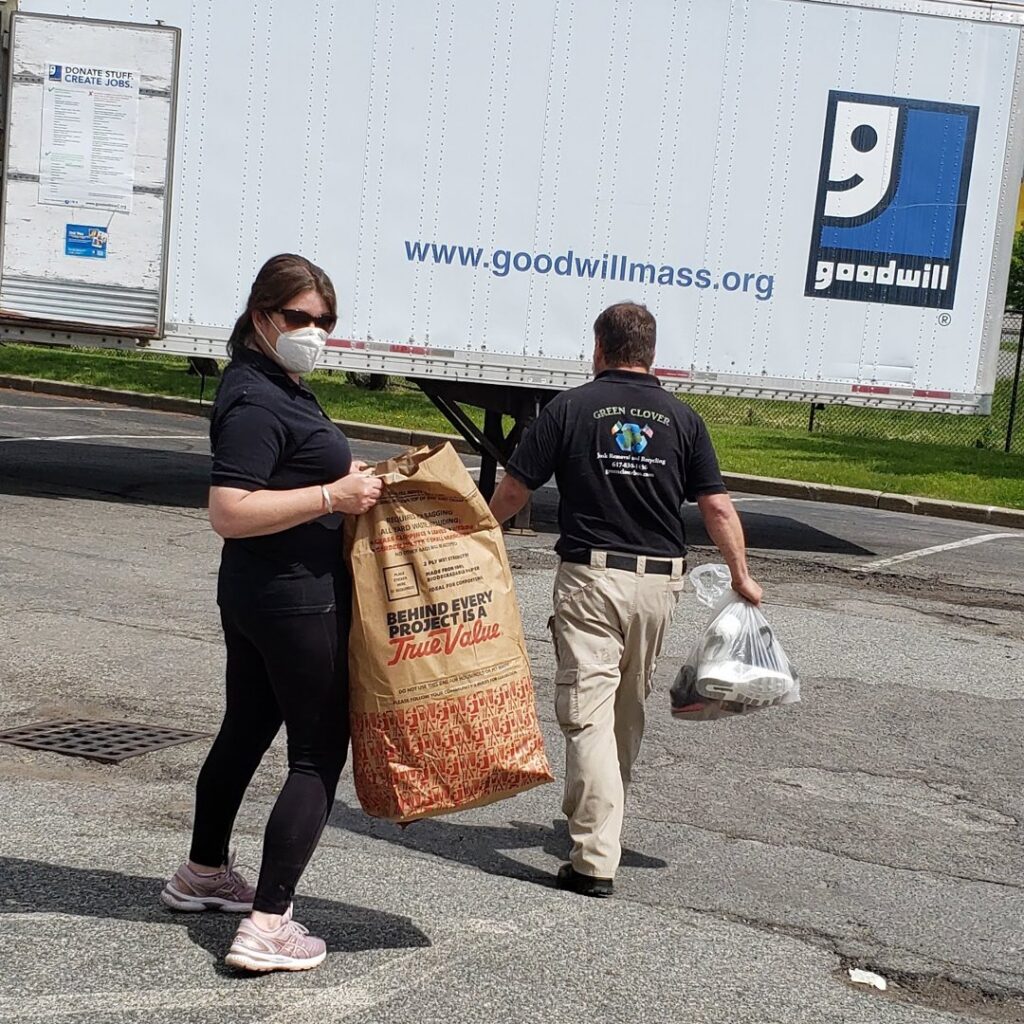 Green Clover team members donating items to a Goodwill trailer as part of their junk removal service in Quincy, MA.
