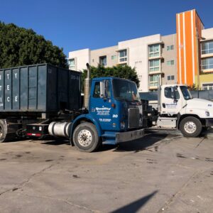 A green commercial dumpster provided by Quality Waste Service, Inc. for junk removal in Los Angeles, CA.