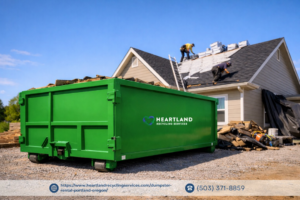 A green dumpster on a construction site for roofing debris removal by Heartland Recycling Services in Portland, OR.