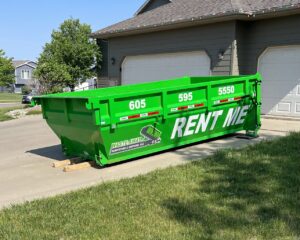 A green roll-off dumpster from Waste-Away Dumpsters & Disposal LLC in a residential driveway in Sioux Falls, SD.