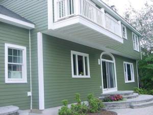 Residential house with new green siding and a white balcony installed by Allaico Construction in Elizabeth, NJ.