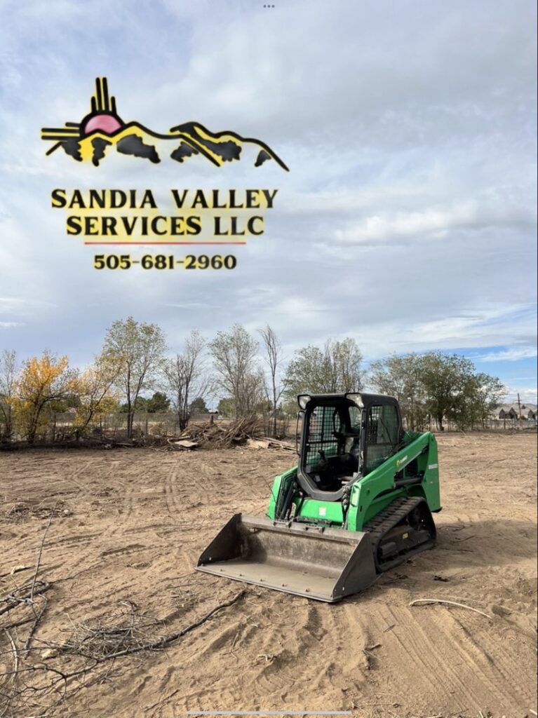 A green skid steer performing land clearing services for Sandia Valley Services LLC in Rio Rancho, NM.