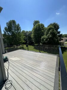 A grey composite deck featuring modern cable railings, expertly installed by Deckscape KC in Kansas City, MO.
