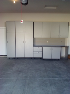 Grey garage cabinets with black trim, a workbench, drawers, and slatwall installed by NW Garage Cabinet Company in Ridgefield, WA.