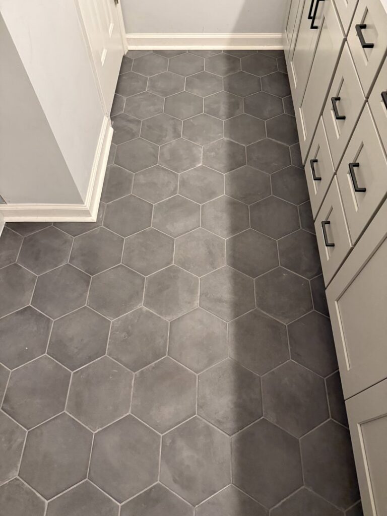 A newly installed grey hexagonal tile floor in a bathroom by Goubar Tile And More in Raleigh, NC.