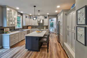 A light grey kitchen renovation with a dark island and wood-look flooring by North Shore Kitchens in Pittsburgh, PA.