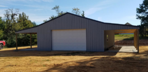 A grey metal garage with a white garage door and an attached carport, constructed by D.H. Construction in Jackson, TN.