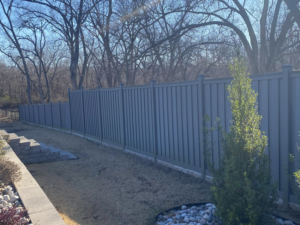 A modern grey privacy fence installed in a residential backyard by Aaron Fence, providing security in Tulsa, OK.