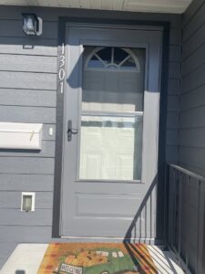 A newly installed grey storm door on a home, a professional handyman service provided by Great Falls Deck & Carpentry in Great Falls, MT.