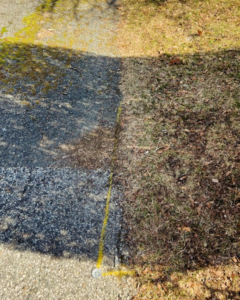 Ground marked with a yellow line on asphalt and grass, indicating preparation for trenching by Blackcap Handyman in Portland, ME.