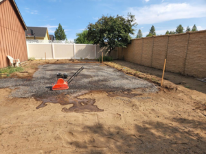 Ground preparation using a plate compactor for an outdoor project by Michel's Fencing in Bend, OR