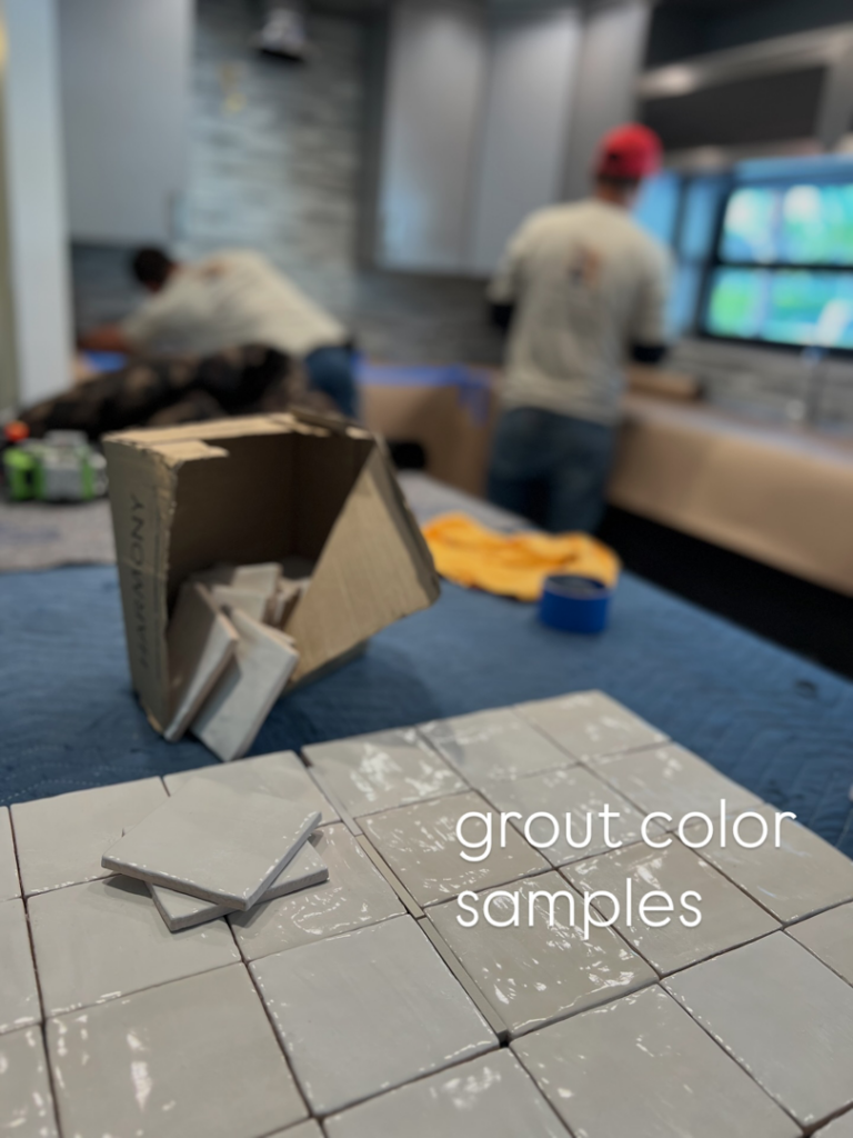 Grout color samples and tiles on a protected surface during a renovation project by Broward Tile Guys in Pompano Beach, FL.
