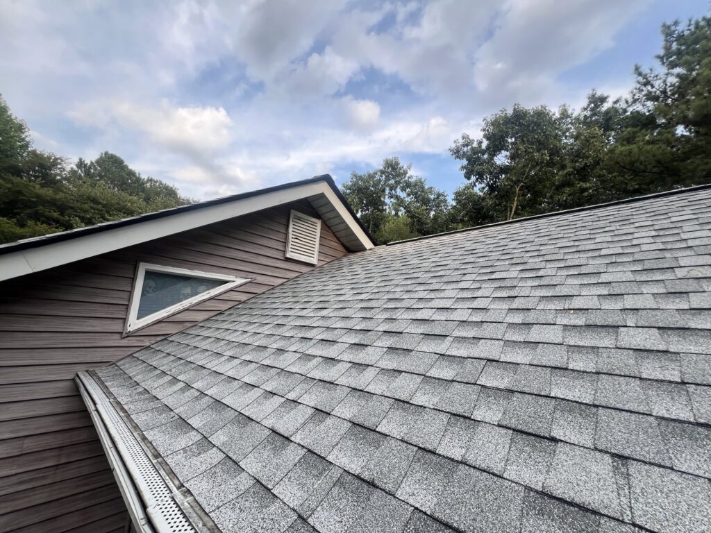 Close-up of a shingle roof with a new gutter guard system installed by Blue Wing Roofing in Augusta, GA