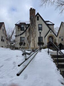 A handyman from Nordic Construction installing or repairing gutters on a house in Plymouth, MN.