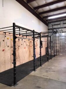 Interior view of a gym with a custom climbing wall and monkey bars installed by Fisher Construction, LLC in Selah, WA.