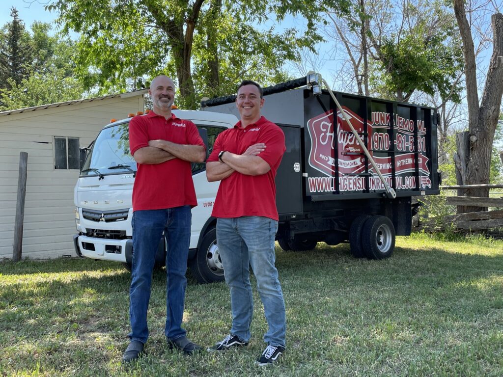 Two team members from Hagen's Junk Removal standing proudly in front of their junk removal truck in Fort Collins, CO.
